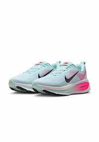 Light blue running shoes with black swoosh, textured mesh upper, pink accents on the heel, and white midsole with "zoomx" branding.