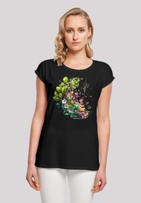 Schwarzes Kurzarm-T-Shirt mit einem bunten floralen Design, das grüne Blätter und rosa Blumen zeigt, auf der Vorderseite bedruckt.