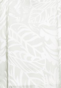 Tessuto leggero e traslucido con un delicato motivo a foglia bianco su sfondo grigio chiaro. Texture liscia con un design fluido.