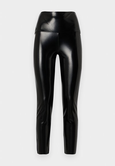 Juodos dirbtinės odos legginsai su aukštu liemeniu, lygaus paviršiaus, siaurėjantys į apačią, ir blizgiu paviršiumi. Nėra matomų siūlių ar puošmenų.
