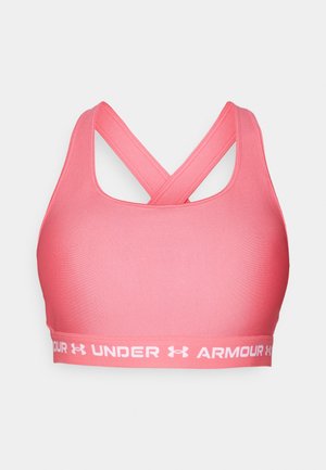 Vaaleanpunainen urheilutoppi, jossa on sileä pinta, ristikkäiset hihnat ja leveä nauha, jossa on valkoinen "Under Armour" -logo. Suunniteltu aktiiviseen käyttöön.
