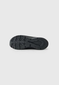 Juodas sportbačių padas su raštuotu protektoriumi ir "Skechers" logotipu, matomas iš apačios ant baltos fono.