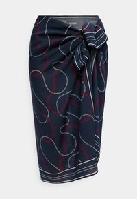 Φούστα τύπου wrap σε ναυτικό μπλε με κόκκινα και λευκά σχέδια αλυσίδας, με μεγάλο ριγέ φιόγκο στη μέση και ριγέ τελείωμα στο κάτω μέρος.