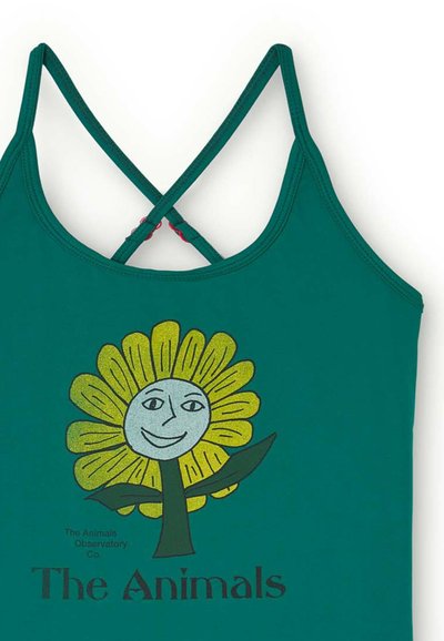 Top verde con spalline incrociate, con una grafica stilizzata di un fiore con una faccia sorridente e il testo "The Animals" sotto.