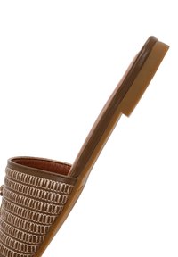 Sandale plate marron avec un design tissé texturé, tige en cuir lisse et semelle plate. Le profil latéral montre une semelle intérieure nervurée et un style minimaliste.