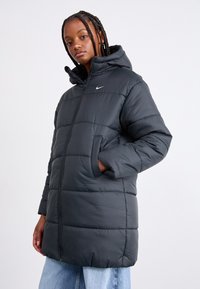 Mustan värvi paksu sulejope kapuutsiga, horisontaalse õmblusega, kahe tasku ja väikese logoga rinnas. Pehme ja soojust hoidva tekstuuriga.