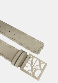 Cintura in pelle beige con bordi intrecciati e una fibbia quadrata ritagliata che mostra il logo "Armani Exchange" in una tonalità contrastante.