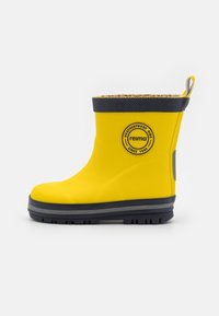 Botte en caoutchouc étanche jaune avec des accents gris, un logo rond et une tige texturée. La botte dispose d'une languette à l'arrière et d'une semelle épaisse.