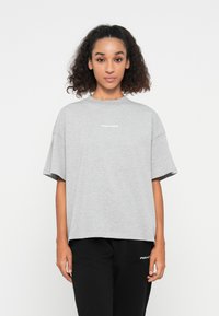 Gray oversized t-shirt made of soft fabric, featuring short sleeves and a crew neckline, with "PEGADOR" printed in white on the front.