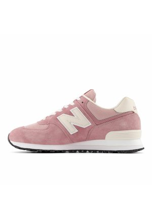 Różowy zamszowy i siateczkowy sneaker z białymi sznurowadłami, kremowym logo „N” i białą amortyzowaną podeszwą z czarną nakrapianą spodem.
