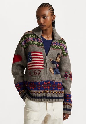 Grauer, gestrickter Reißverschluss-Pullover mit bunten Mustern, einer amerikanischen Flagge und einem Bärenmotiv. Rippbündchen und -ärmel mit verschiedenen strukturierten Abschnitten.