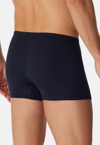 Boxer da uomo blu navy realizzati in morbido cotone, con una vestibilità aderente, vita elastica e superficie liscia senza cuciture o motivi visibili.