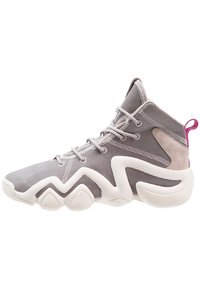 Wysoka sportowa obuwie wykonane z szarej siateczki z zamszowymi akcentami. Posiada białą rzeźbioną podeszwę oraz różową pętlę z tyłu.