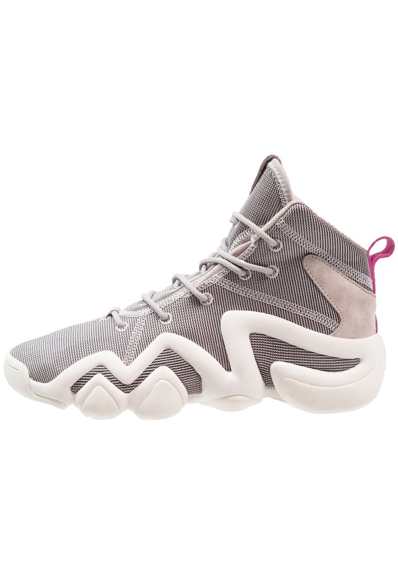Wysoka sportowa obuwie wykonane z szarej siateczki z zamszowymi akcentami. Posiada białą rzeźbioną podeszwę oraz różową pętlę z tyłu.