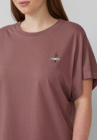 Kurze Ärmel, lockeres T-Shirt in Mauve mit einem strukturierten, bestickten Design eines Pflasters mit Blumen. Weiches Baumwollmaterial.