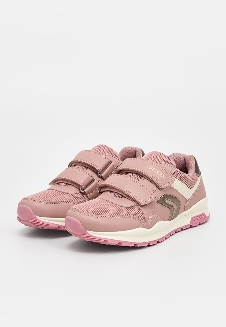 Baskets de sport roses avec une tige en mesh et synthétique, dotées de deux bandes Velcro, d'accents blancs et d'une semelle en caoutchouc texturée.