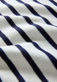 Tela de algodón con rayas horizontales blancas y azul marino, que muestra una textura suave y una ligera curvatura en el material.