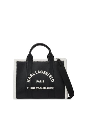 Czarna skórzana torba typu tote Karl Lagerfeld z białym obszyciem ze skóry owczej, dwoma uchwytami, paskiem na ramię i białym logo tekstowym z przodu.