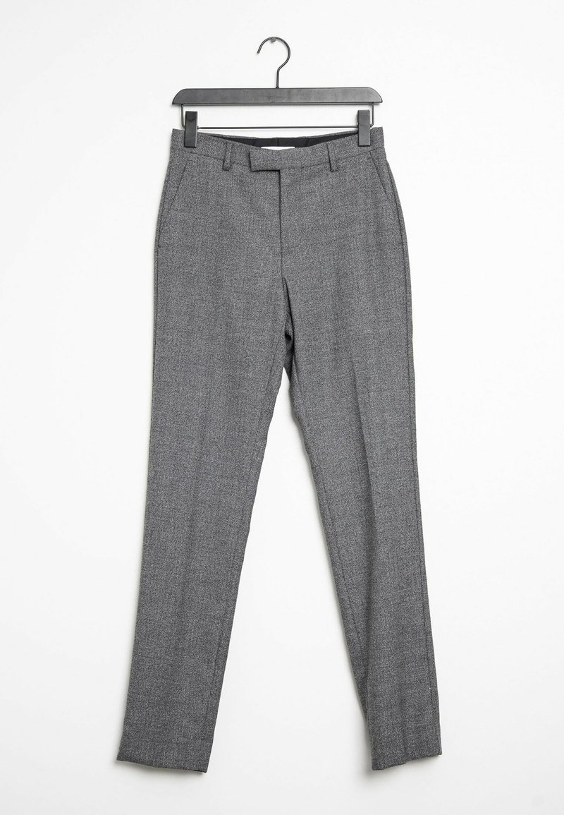 Pantalon de costume gris slim avec passants de ceinture et poches latérales suspendu sur un cintre noir sur fond blanc.