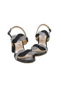 Sandali con tacco neri e argentati con una tomaia testurizzata e scintillante, design open toe e cinturino alla caviglia regolabile. Presentano un tacco a blocco.