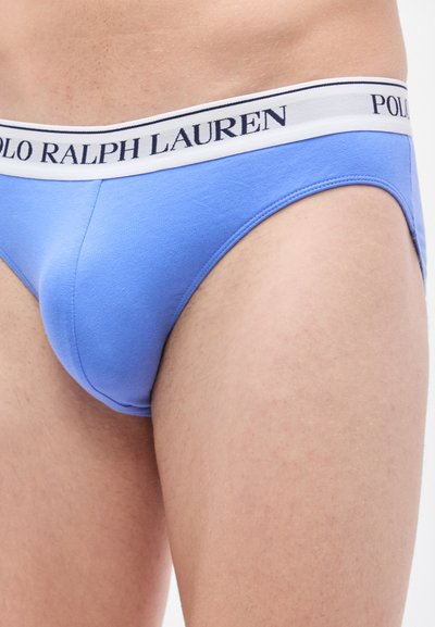 Ανοιχτό μπλε βαμβακερά εσώρουχα με λευκή ζώνη μέσης που φέρει τη λέξη "POLO RALPH LAUREN" σε ναυτικό μπλε. Λείο υφή, εφαρμοστό σχέδιο, χωρίς ορατά σχέδια.