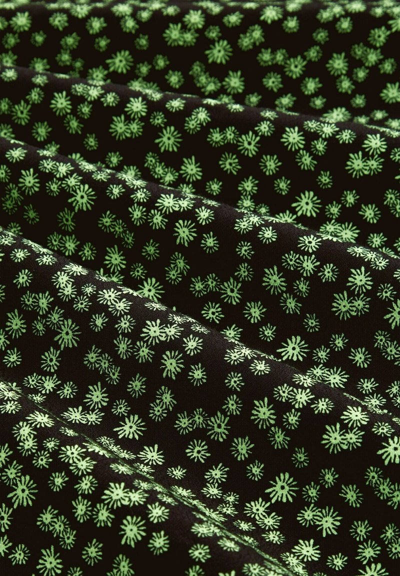 Schwarzer Stoff mit einem wiederkehrenden Muster aus kleinen, leuchtend grünen floral Motiven, die verschiedene Formen und symmetrische Designs über die Oberfläche verteilen.