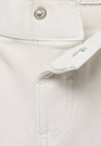 Tecido de denim alb cu o buzunar vizibil și o închidere cu buton metalic. Prezintă o textură slabă și detalii de cusătură curate.