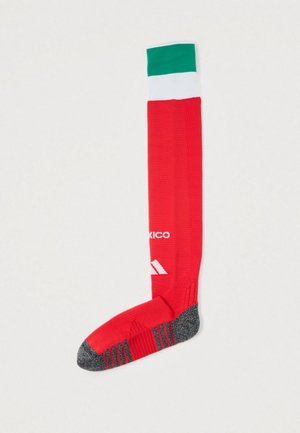 Czerwona skarpetka do kolan z zielonym i białym paskiem na górze, szarym palcem oraz piętą oraz białym logo i tekstem Adidas na nodze.