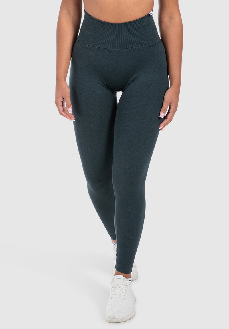 Mörkgröna högmidjade leggings gjorda av stretchigt material, med en slät yta och en kroppsnära design.