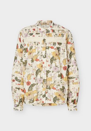 Bluzka z długim rękawem zapinana na guziki z wielokolorowym kwiatowym wzorem, koronkowymi zdobieniami na piersi i rękawach oraz marszczonymi mankietami na jasnym tle.