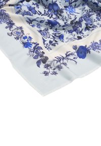 Zachte witte stof met blauwe bloem- en fruitpatronen, met gedetailleerde bloemen en bladeren in verschillende tinten blauw en zwart.