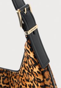 Smešasta torbica s uzorkom leoparda u smeđoj boji s crnim kožnim remenom, koja se ističe zlatnim kopčanjem i graviranim brandom na remenu.