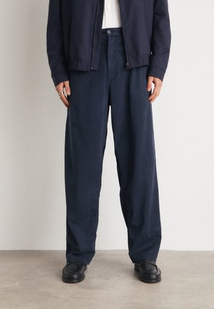 Navy blue, loose-fit trousers with a simple design, made from lightweight fabric, featuring a subtle texture and elastic waistband.
