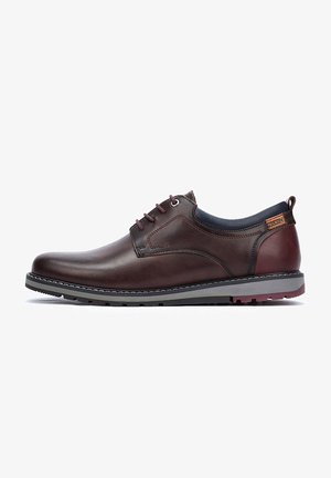 Zapatos marrones de cuero con cordones, con una textura suave, suela gris contrastante y detalles de costura; cuentan con una pestaña en el talón.