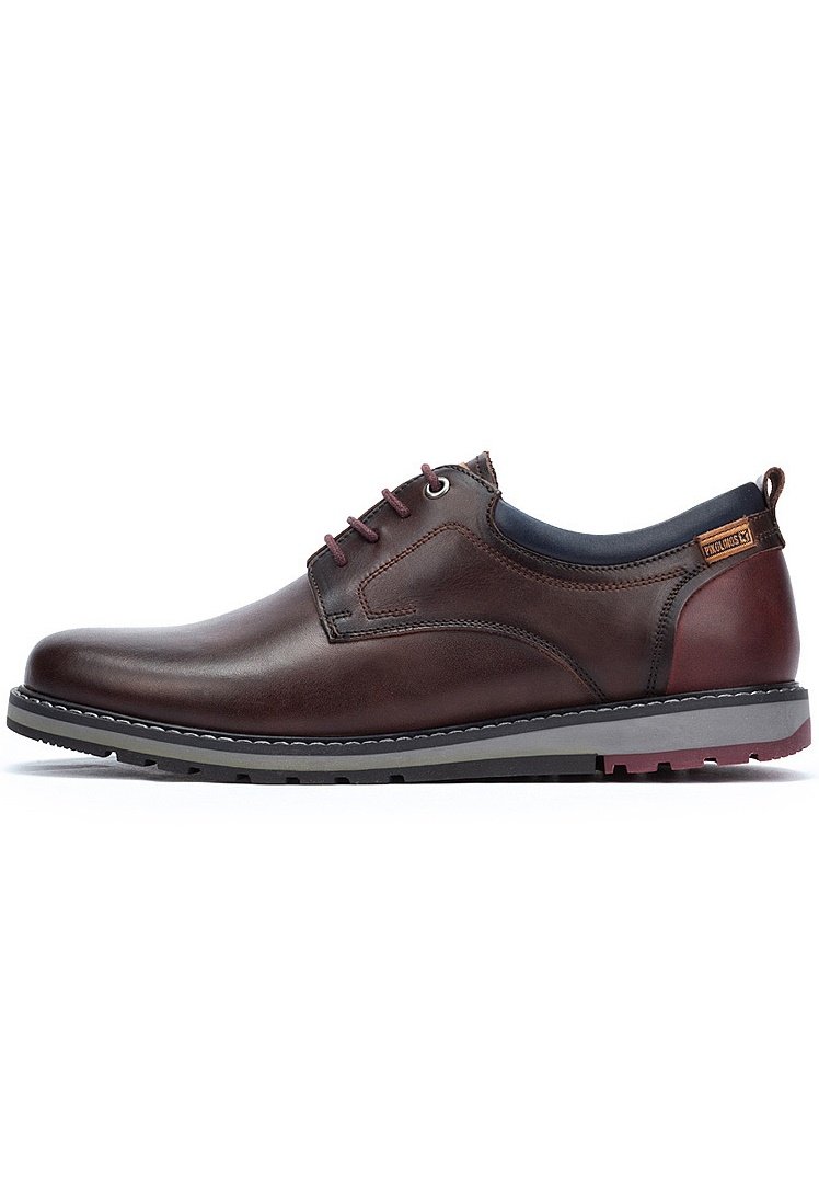 Zapatos marrones de cuero con cordones, con una textura suave, suela gris contrastante y detalles de costura; cuentan con una pestaña en el talón.