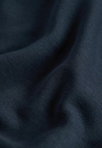 Dark navy fabric displaying a smooth, textured surface with subtle stretch, showcasing a fine weave pattern and soft drape.