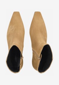 Helle Wildleder-Stiefeletten mit spitzem Zehenbereich, seitlichem Reißverschluss und glattem schwarzen Innenfutter. Der Absatz ist etwa 6,5 cm hoch.