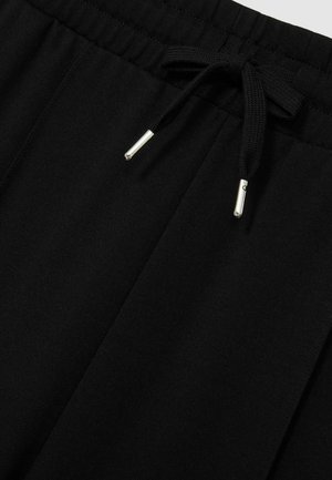 Schwarze Jogginghosen mit einem elastischen Bund und einem Kordelzug mit metallischen Enden. Glattes Material mit einfacher Textur und ohne Muster.