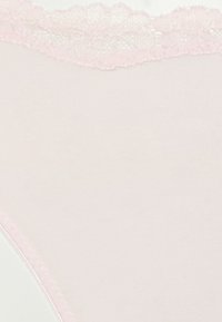 Roze katoenen string met een kantafwerking in de taille, met gladde stof en een minimalistisch ontwerp. Geen extra patronen of hardware aanwezig.