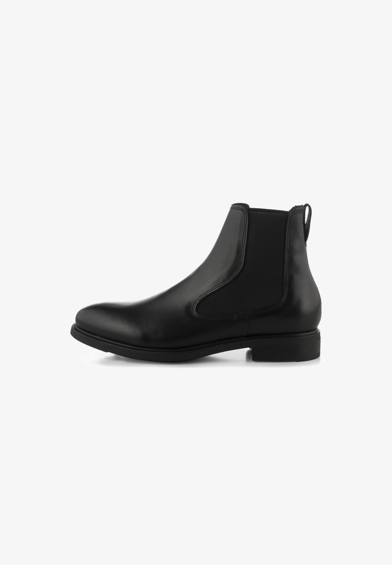 Botte Chelsea en cuir noir avec panneaux latéraux élastiques, talon bas, bout rond et languette à l’arrière sur fond blanc.