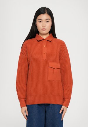 Ribbed, burnt orange pullover with a collar, button front, and a single chest pocket. Features long sleeves with contrasting cuffs.