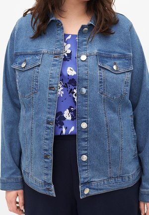Denim jacket in mid-blue with classic collar, two chest pockets, silver buttons, and slight fading on sleeves. Floral top underneath.