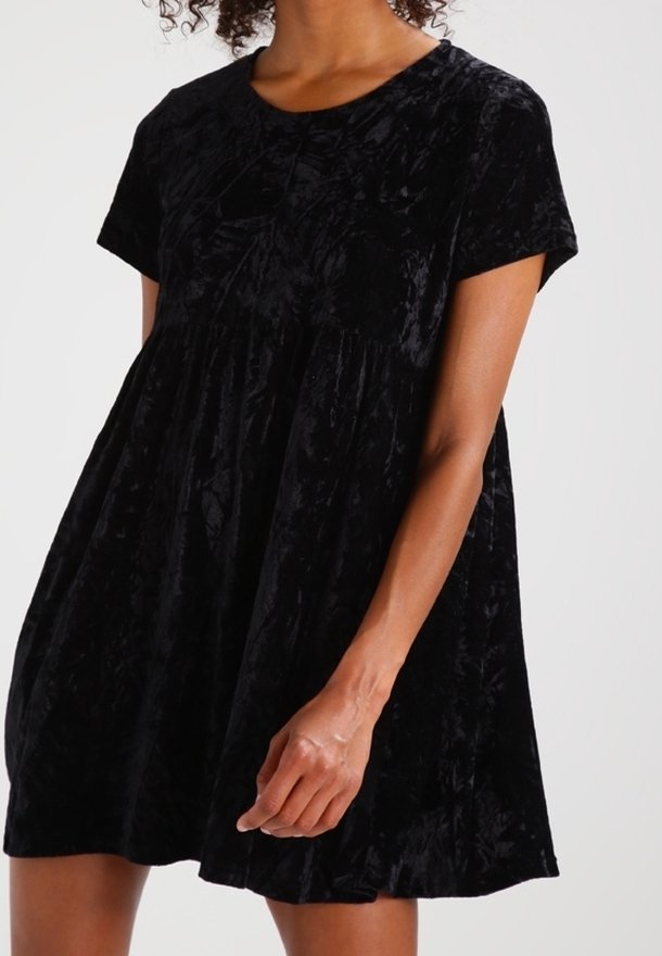Abito in velluto nero con maniche corte, scollatura arrotondata e vita arricciata. Presenta una texture morbida e una vestibilità ampia e fluida.