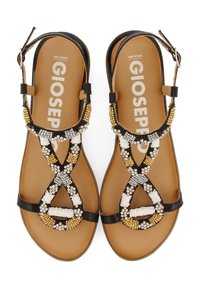 Sandalias negras con cuentas que presentan un intrincado trabajo de cuentas en dorado, blanco y plateado. Suela plana con una correa ajustable en el tobillo y diseño abierto.