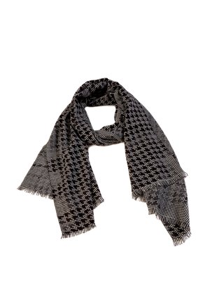 Sort-hvidt halstørklæde med hundetandmønster og frynser i kanterne, løst foldet mod en hvid baggrund.