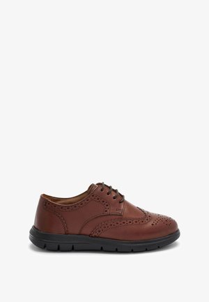 Bruine leren brogue-schoen met geperforeerde details, veters aan de voorkant en een dikke zwarte rubberen zool.