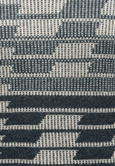 Manta de malha com um padrão geométrico de riscas alternadas em cinzento escuro e branco sujo, apresentando texturas e desenhos variados por toda a peça.