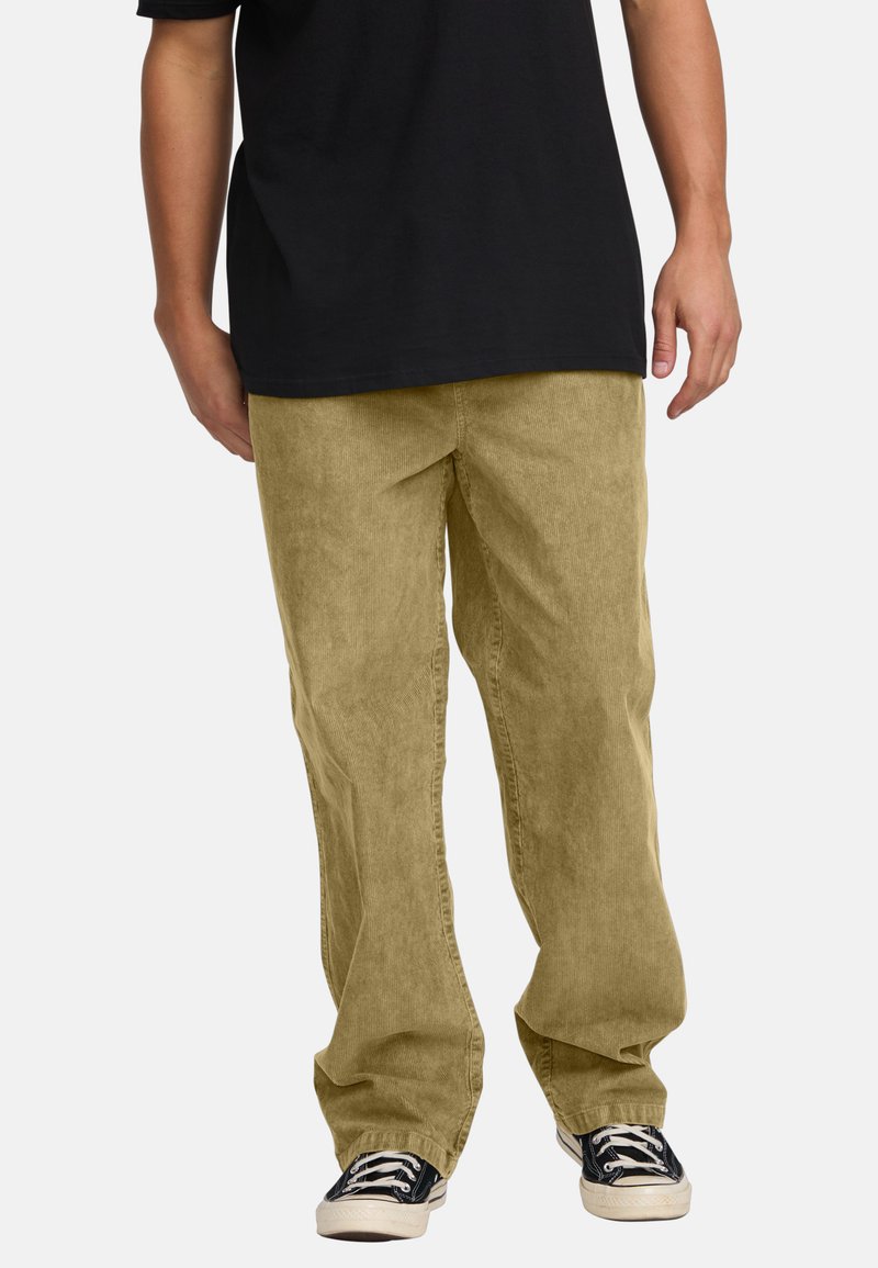 Light beige corduroy pants with a relaxed fit, featuring straight legs and subtle texture. Paired with black canvas sneakers.