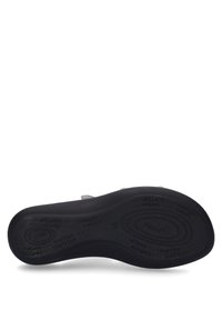 Black rubber shoe sole with a textured surface. Features embossed brand names and a rounded shape for comfort and support.