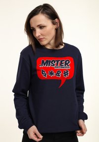 Felpa blu navy in cotone, con una grande grafica a fumetto rossa contenente il testo "MISTER ZEEK@SINCE1976" e simboli.